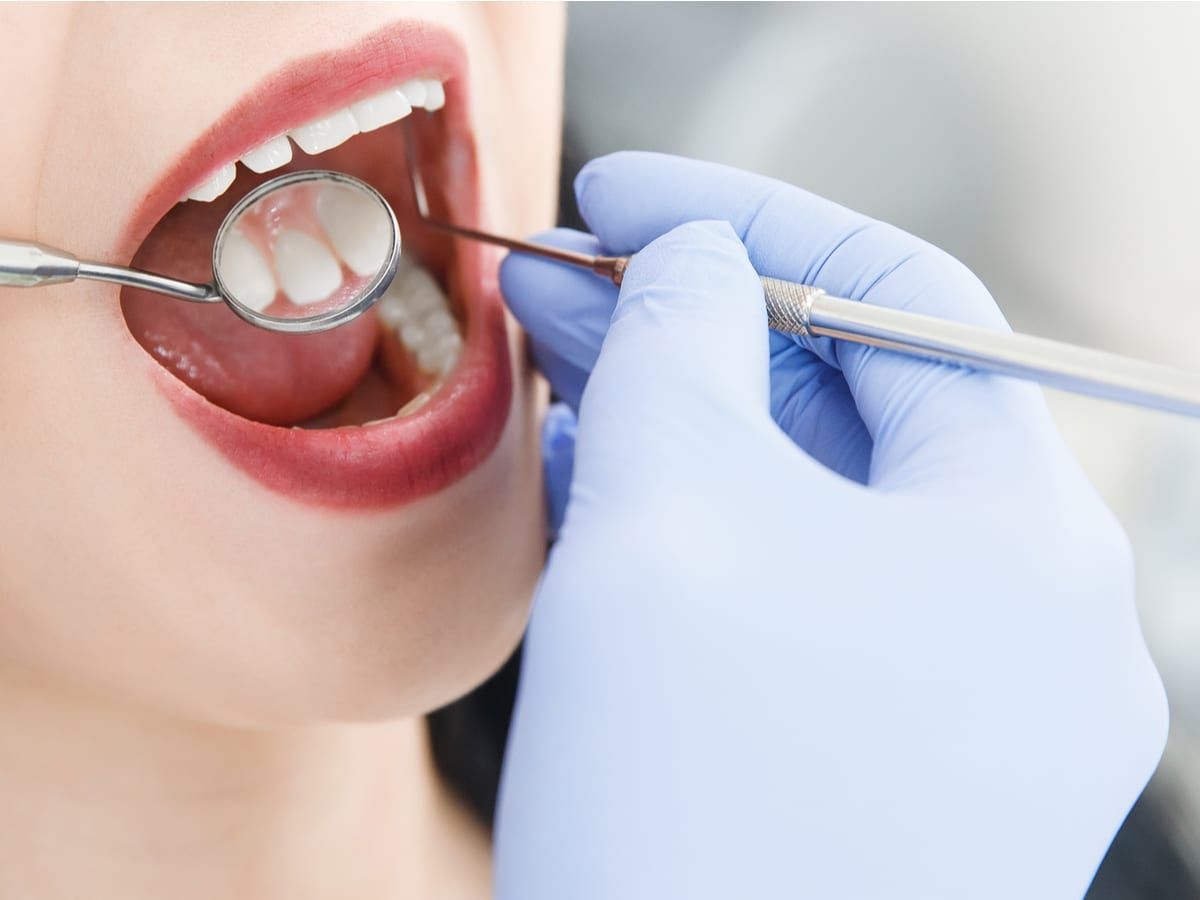 Dentist viewing patient's mouth with oral mirror